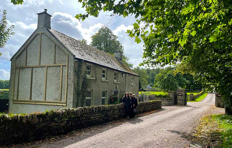 Three travelers by an Irish farmhouse
